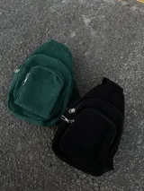 Conjunto de dos riñoneras de pana, una color verde oscuro y otra color negro, con correa ajustable.