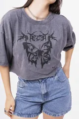 Remera gris oscuro con efecto lavado, corte crop y estampado frontal de mariposa con detalles tribales en negro.