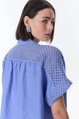 Vestido camisero celeste de lino con cuello mao, manga corta con detalle de calado y bolsillo de crochet.