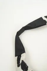 Bolso tipo tote bag con estampado de lunares irregulares en blanco y negro, con base y asas cortas en color negro.