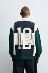 Polo de manga larga con corte relaxed fit, confeccionado en tejido con algodón. Presenta un diseño color block en azul marino, blanco y verde, con cuello solapa con cierre frontal de botonadura. Cuenta con bordados y parches combinados a contraste en delantero y espalda, y acabados en rib.
