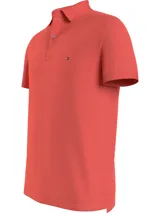 Chomba Tommy Hilfiger de corte slim, color salmón, con cuello clásico, cartera de dos botones y logo de la marca bordado en el pecho.