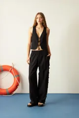 Pantalón negro de algodón y lino, corte recto, con cintura elástica y mostacillas en los laterales.