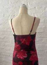 Minivestido de microtul con estampado de flores rojas sobre fondo negro.