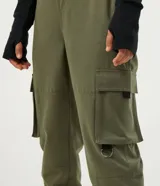 Pantalón jogger color verde militar, con cintura elástica ajustable con cinturón de hebilla plástica. Tiene bolsillos laterales tipo cargo con fuelle y puños elásticos.