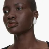 Aros de clip Swarovski Sublima con baño de rodio y cristales transparentes engastados en pavé. Diseño abovedado con patrón Meteora de cristales de distintos tamaños.