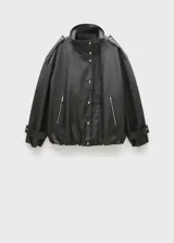 Anorak negro oversize con cuello alto, cierre frontal con botones y cremallera oculta, mangas largas con puños abotonados y bolsillos laterales con cremallera.