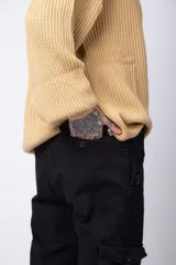 Pantalón cargo color beige con bolsillos laterales con solapa y botón. Corte ajustado.