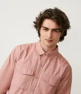 Camisa manga larga color rosa con capucha gris, cierre con botones, bolsillos frontales y corte recto.