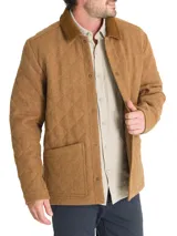 Chaqueta acolchada gris con patrón de rombos, cuello de pana marrón, cierre con broches metálicos, bolsillos frontales y bolsillo interno.