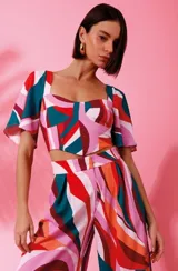 Top corto estampado multicolor, confeccionado en crepe, con escote cuadrado y mangas cortas acampanadas.