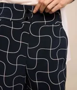 Short de vestir azul marino con estampado geométrico de líneas blancas, tiro alto, bolsillos laterales y cierre frontal con doble botón.