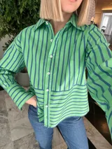 Camisa verde con rayas verticales azules, de corte recto y manga larga.