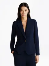 Americana azul marino de crepé con corte slim, solapas con muescas, botonadura sencilla con cierre de botón, dos bolsillos de ojal en la cintura, detalles distintivos de Tommy Hilfiger y logo esmaltado de Tommy Hilfiger en el puño.
