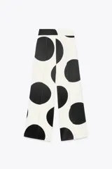 Pantalón de tiro medio confeccionado con hilatura en mezcla de viscosa y lino. Diseño con lunares grandes en blanco y negro. Pierna ancha con detalle de raya planchada. Cierre lateral con cremallera oculta en costura.