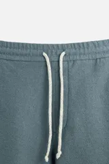 Bermuda azul de tejido con mezcla de algodón, corte relaxed fit, cintura elástica ajustable con cordón, bolsillos delanteros y detalle de bolsillo trasero de vivo.