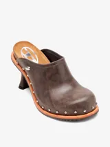 Zueco marrón de cuero con tacón de aguja, punta cerrada y apliques metálicos plateados.