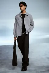 Sobrecamisa gris de tejido suave con cuello inglés, tapeta lisa, corte estándar, bolsillos superiores abiertos, abertura con botón en los puños, canesú en la espalda y bajo recto.