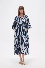 Vestido midi holgado con estampado abstracto en tonos azul marino, azul claro y blanco. Presenta cuello mao, botones frontales y cordón ajustable en la cintura.