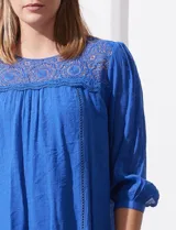 Blusa verde agua de gasa marca Figueroa & Flower, con cuello redondo y aplique de crochet. Tiene mangas 3/4 amplias con puño y botón, y forro interno a tono.