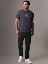 Remera gris con cuello redondo y mangas cortas. Estampado frontal con diseño gráfico que imita un sello de la ciudad de Nueva York.
