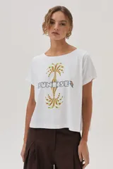 Remera blanca de algodón con estampa de palmeras y la palabra "Sunrise" en el frente.