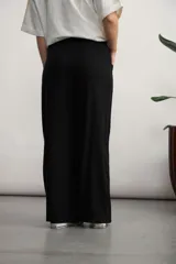 Pantalón negro de corte palazzo, con cintura alta con cordón ajustable y bolsillos laterales.