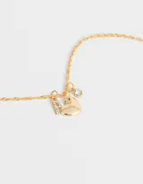 Cadena dorada con dije de strass y corazón de metal.