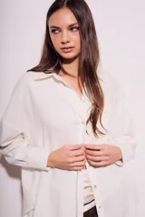 Camisa oversize color crudo, confeccionada en lino y viscosa, con cuello clásico, cierre frontal con botones de nácar y manga larga.