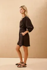 Vestido corto negro de manga larga con cuello mao y lazo a tono en la cintura.