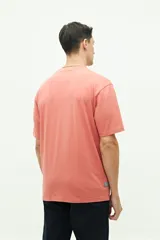 Remera gris claro de manga corta con cuello redondo y estampado azul con texto circular en el pecho.