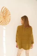 Sweater color ocre de lana de cordero con cuello alto abotonado y calce oversize.