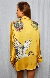 Camisa amarilla estampada con flores y grullas, de corte holgado, cuello solapa y manga larga.