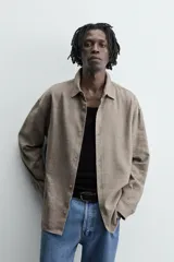 Camisa marrón claro de lino y viscosa, corte holgado, manga larga con puños abotonados y cierre frontal con botones.