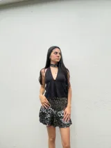 Top halter negro de encaje con escote pronunciado en V y detalle de tiras finas en la espalda.