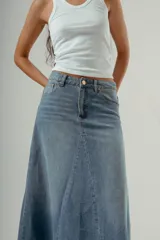 Falda larga de denim, tiro medio, color celeste claro con efecto desgastado. Presenta un corte amplio con paneles verticales que le dan volumen y caída.
