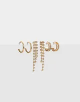 Set de tres pares de aros dorados: argollas clásicas, argollas dobles con strass y aros colgantes con strass.