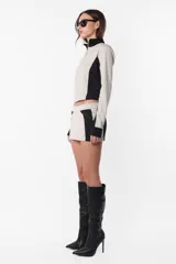Campera deportiva negra con recortes grises en mangas y laterales. Cierre frontal y calce slim fit. Estampa de logo a tono en el recorte delantero.