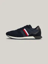 Zapatillas Tommy Hilfiger de estilo running, color azul marino con detalles en rojo, blanco y gris. Confeccionadas en poliéster con interior de poliéster, plantilla extraíble de goma termoplástica y poliuretano, y suela de goma dentada. Presentan cinta distintiva en el lateral, paneles con mezcla de texturas y parche con logo en la lengüeta.