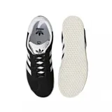 Championes Adidas Gazelle negros con las tres tiras blancas y detalles dorados.