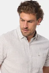 Camisa de manga corta a cuadros, color blanco con líneas celestes y beige. Tiene un bolsillo en el pecho y logo bordado. Corte slim fit.