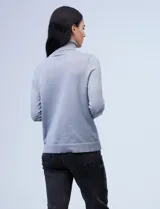 Polera de punto fino marca Nienty, color blanco, con cuello alto volcado y mangas largas con detalle de tajo en los puños.