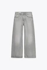 Pantalón de jean gris de corte ancho, tiro medio, con trabillas y cinco bolsillos. Cierre frontal con cremallera y botón metálico.