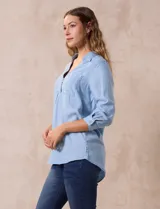 Blusa celeste de lyocell con cuello con solapa, escote en V y cierre con botones. Tiene un bolsillo en el pecho, mangas 3/4 con puño y botón.