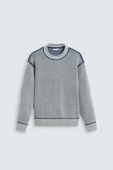 Sweater de punto a rayas verticales azul marino y blanco, con cuello redondo y mangas largas. Terminaciones en rib gris con borde azul marino.