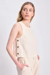 Top color crudo sin mangas de lino, con botones de madera en el lateral.
