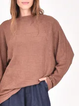 Buzo negro de tejido waffle, con cuello redondo y calce holgado.