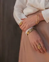 Pulsera tipo esclava abierta, con acabado rústico y textura irregular, en tono plateado. Se vende por unidad.