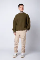 Pantalón cargo color beige con bolsillos laterales con solapa y botón. Corte ajustado.