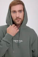 Canguro verde con capucha y cordones ajustables, bolsillo tipo canguro y puños y bajo acanalados. Estampado en relieve con el texto "Originals Studio BROUGHT TO YOU BY JACK&JONES® DESIGNED IN COPENHAGEN".
